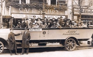 Dorothy on a tour bus in Berlin, 1922. She is sitting at the rear of the bus in a wide-brimmed, white hat and wearing glasses