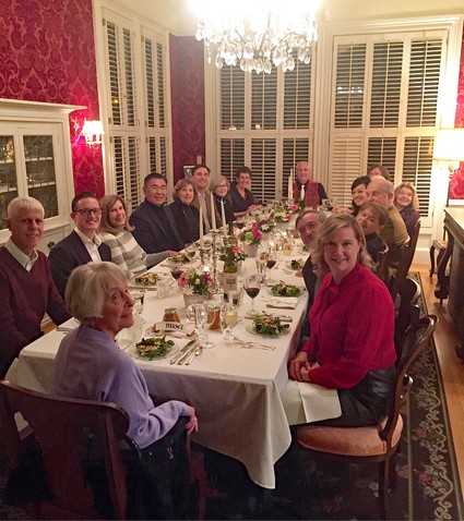 Masel, at the head of the table, celebrating a New Year's dinner with the entire Farrington board and guests